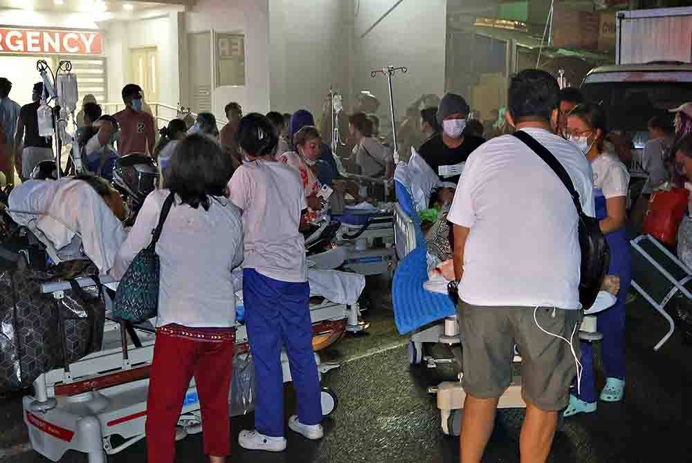 Penduduk dan kakitangan perubatan memindahkan pesakit dari dalam hospital selepas gempa bumi berukuran 7.6 melanda Bandar Butuan, di selatan pulau Mindanao pada Sabtu. - Foto AFP