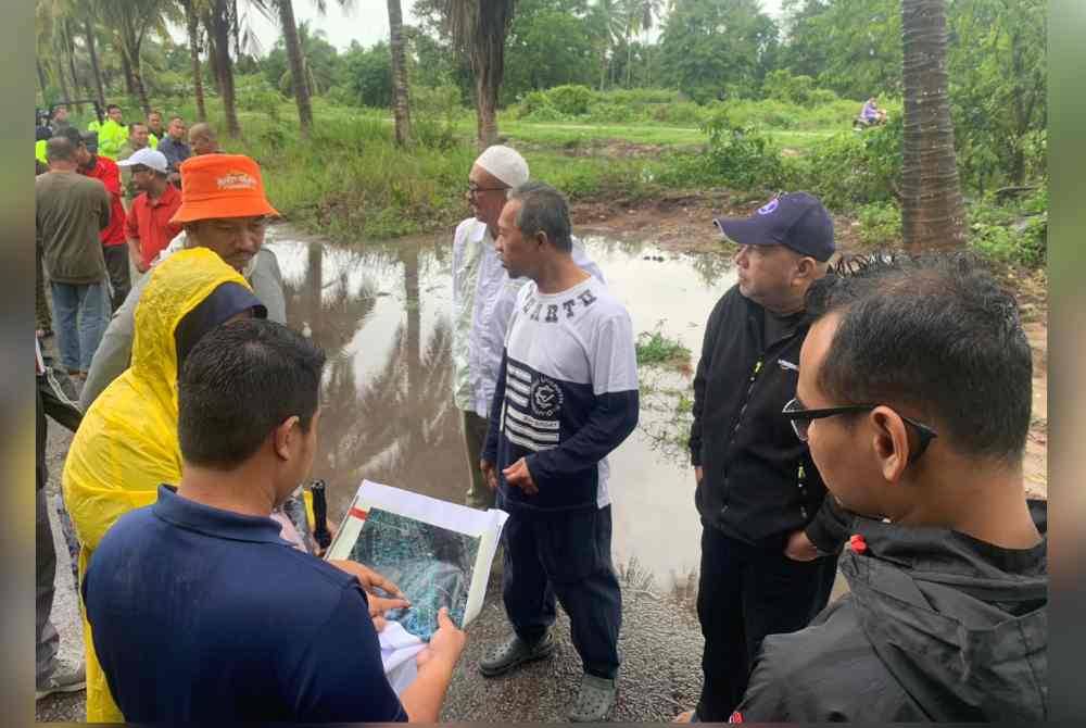 Zameri (tengah) melawat kawasan tali air bersama agensi terlibat yang didakwa menjadi punca banjir di Taman Bator Harmoni.