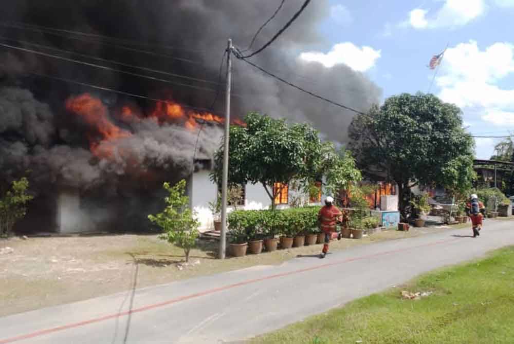 Anggota Bomba dan Penyelamat memadamkan kebakaran sebuah rumah yang turut menyebabkan tiga kenderaan musnah dalam kejadian di Kampung Delek, Klang pada Isnin.