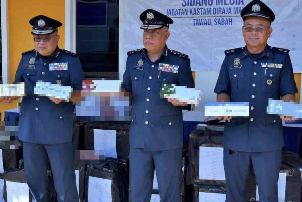 Mohd Nasir (tengah) menunjukkan sebahagian rokok seludup yang dirampas pada sidang media, Selasa. - Foto Benama