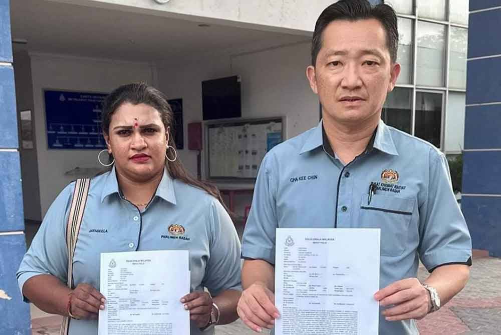 Kee Chin (kiri) menunjukkan laporan polis yang dibuat di IPD Seremban pada Selasa.