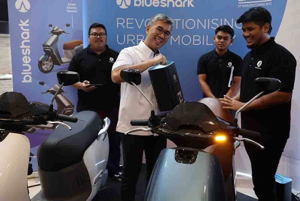 Tengku Zafrul (dua dari kiri) melihat motosikal elektrik pada perasmian Persidangan Kenderaan Elektrik 2023 di Menara MIDA baru-baru ini. - Foto Bernama