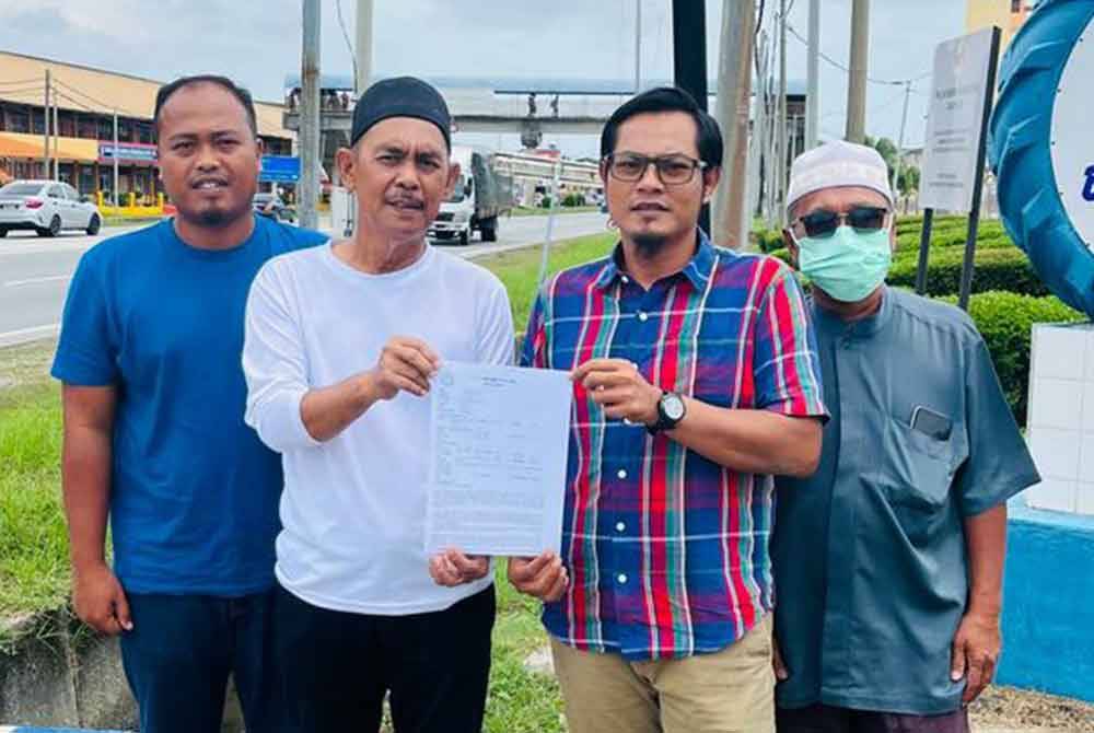 Isa (dua dari kiri) dan Mohd Shahrul (dua dari kanan) bersama dua lagi ahli Amanah Kawasan Tanjong Karang membuat laporan polis di Balai Polis Tanjong Karang pada Khamis.