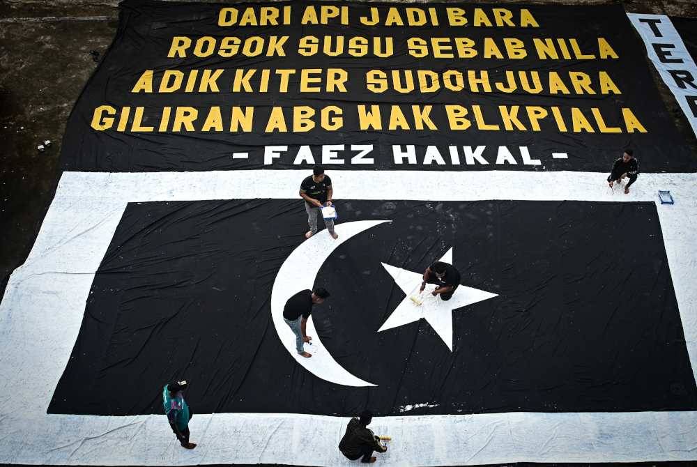 Penyokong Bola Sepak Terengganu FC atau lebih dikenali ‘Geng 12 FC’ menyiapkan bendera negeri dan kain rentang bersaiz gergasi menjelang kehangatan perlawanan akhir Piala Malaysia ketika tinjauan di Gong Badak. - Foto Bernama