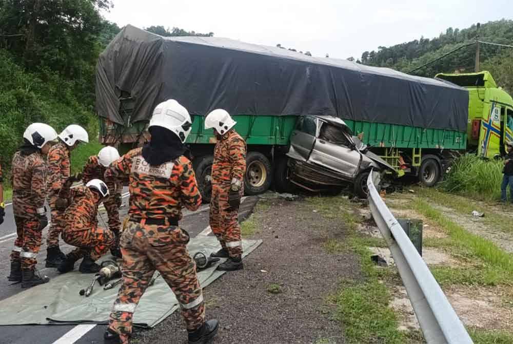 Pemandu dan penumpang sebuah kereta maut selepas terlibat kemalangan dengan treler di Jalan Gerik-Jeli, petang Khamis. - Foto ihsan Bomba Perak