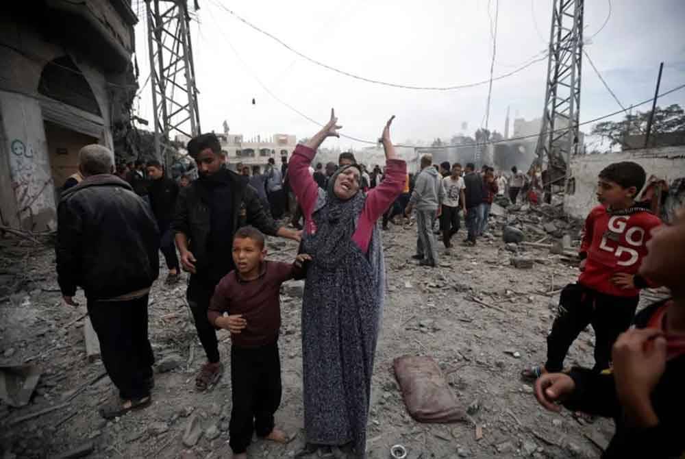 Seorang wanita Palestin memberi isyarat selepas serangan udara Israel di kem pelarian Khan Younis di selatan Semenanjung Gaza. - Foto: AP