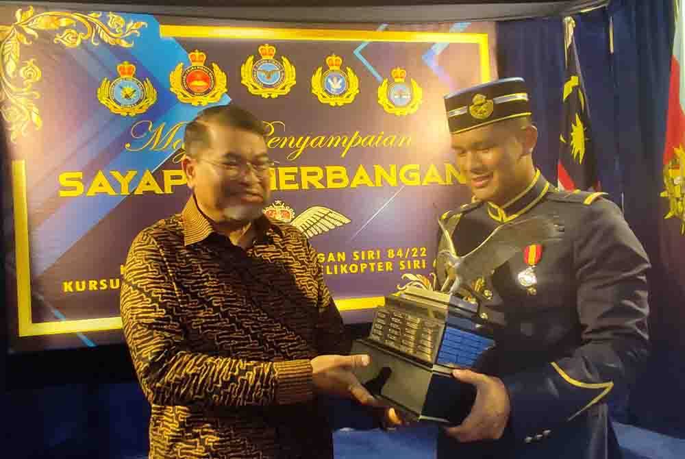 Leftenan Muhammad Salihin (kanan) bersama bapa, Mohd Sabri Sulaiman sambil memegang Piala Panglima Tentera Udara (Pelatih Terbaik Keseluruhan Sayap Kaku) selepas Upacara Penyampaian Sayap Penerbangan di Kolej Tentera Udara pada Sabtu.