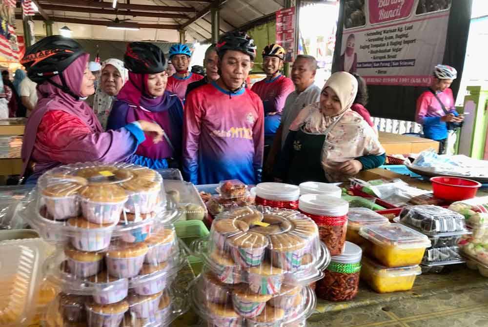 Jasri (dua dari kanan) melawat peniaga di Pasar Kubang Pasu sempena Program Jelajah e-Kasih@ Kota Lama, di sini pada Sabtu.