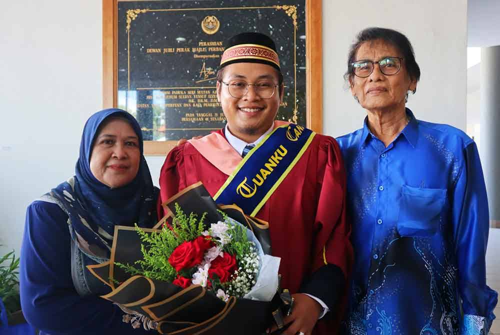 Mohamed Aiedil Putera (tengah) di samping ibu bapanya yang hadir sempena Istiadat Konvokesyen Universiti Sultan Azlan Shah (USAS) ke-16 di Dewan Jubli Perak, Kuala Kangsar pada Sabtu.