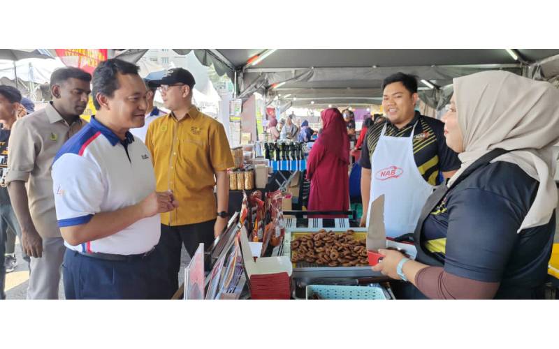 Mohd Salem beramah mesra dengan seorang peserta Program Usahawan USHANiaga yang menyertai Karnival UDA@Perak 2023.