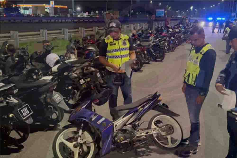 Pegawai polis melakukan pemeriksaan pada motosikal yang dinaiki sekumpulan mat rempit.