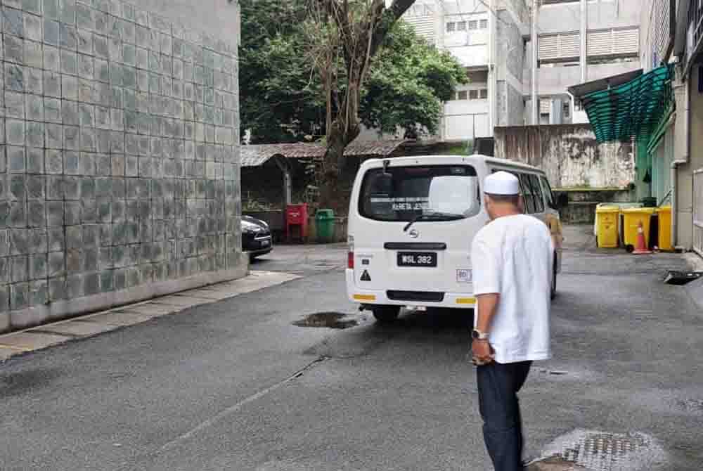 Waris keluarga menunggu kedatangan van jenazah Jabatan Patologi Forensik, PPUM untuk membawa kedua-dua mayat terbabit pada petang Ahad.