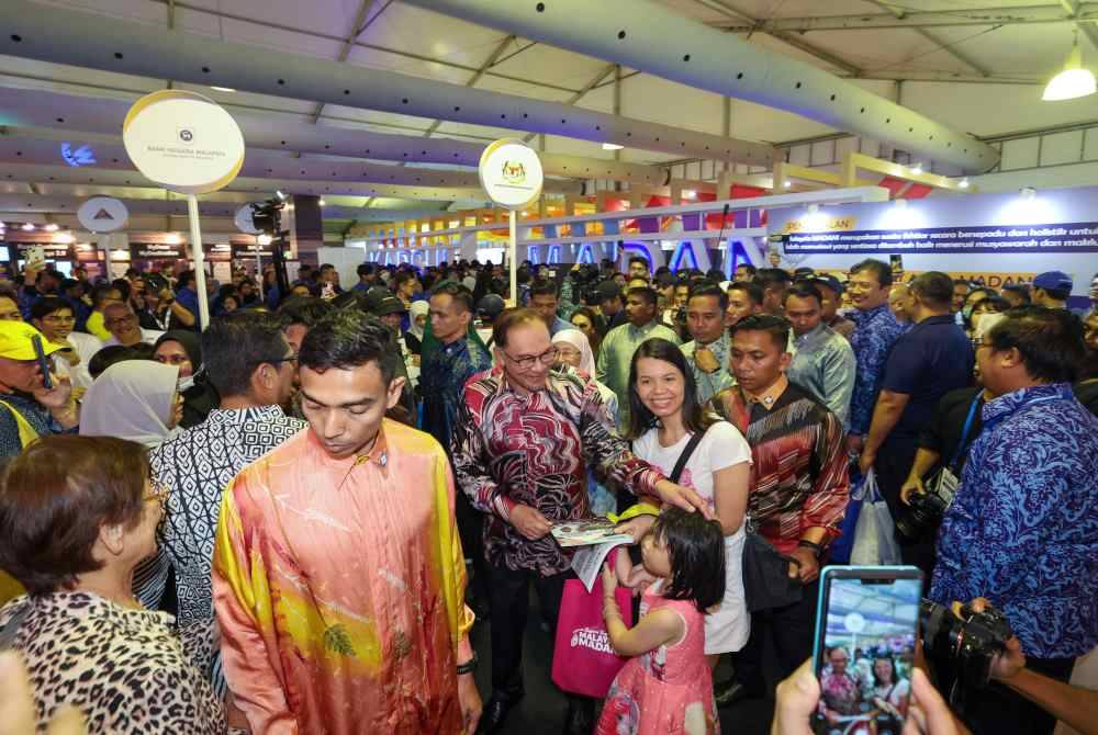 Anwar beramah mesra dengan orang ramai pada Penutup Program Setahun Bersama Kerajaan Madani di pekarangan Stadium Nasional Bukit Jalil hari ini. - Foto Bernama