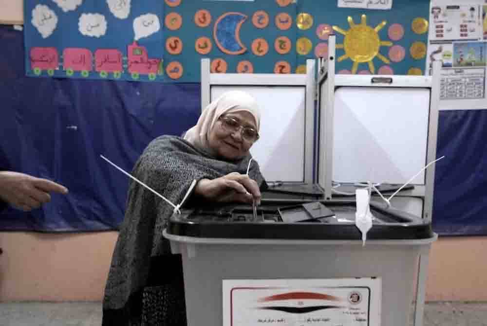 Seorang wanita membuang undi untuk pilihan raya presiden di pusat mengundi di Kaherah, Mesir pada Ahad - Foto: AP