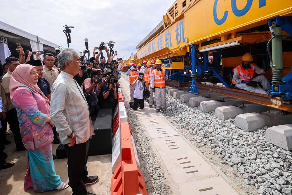 Yang di-Pertuan Agong, Al-Sultan Abdullah Ri&#039;ayatuddin Al-Mustafa Billah Shah dan Raja Permaisuri Agong, Tunku Azizah Aminah Maimunah Iskandariah berkenan mencemar duli menyaksikan proses pemasangan landasan pertama projek Laluan Rel Pantai Timur (ECRL) selepas menyempurnakan gimik perasmian pemasangan landasan tersebut di Tapak Stesen ECRL Seksyen 10, Gebeng pada Isnin. - Foto Bernama