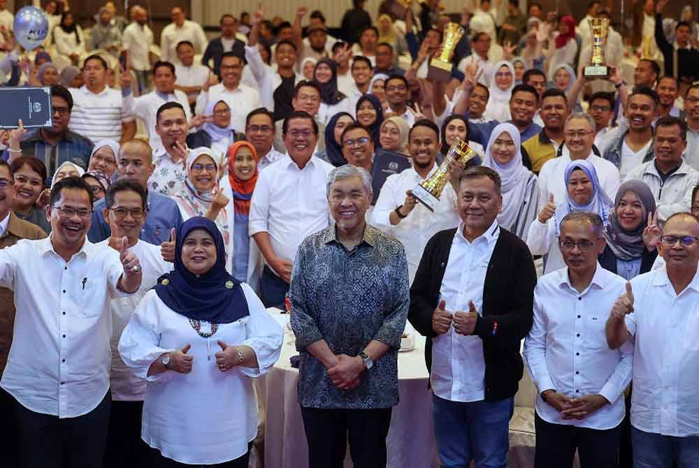 Ahmad Zahid (empat dari kanan) bergambar kenangan bersama kakitangan dan agensi di bawah kementerian Kemajuan Desa dan Wilayah ketika hadir ke Majlis Apresiasi Karnival Usahawan Desa (KUD) di Bangi malam ini. - Foto: Bernama