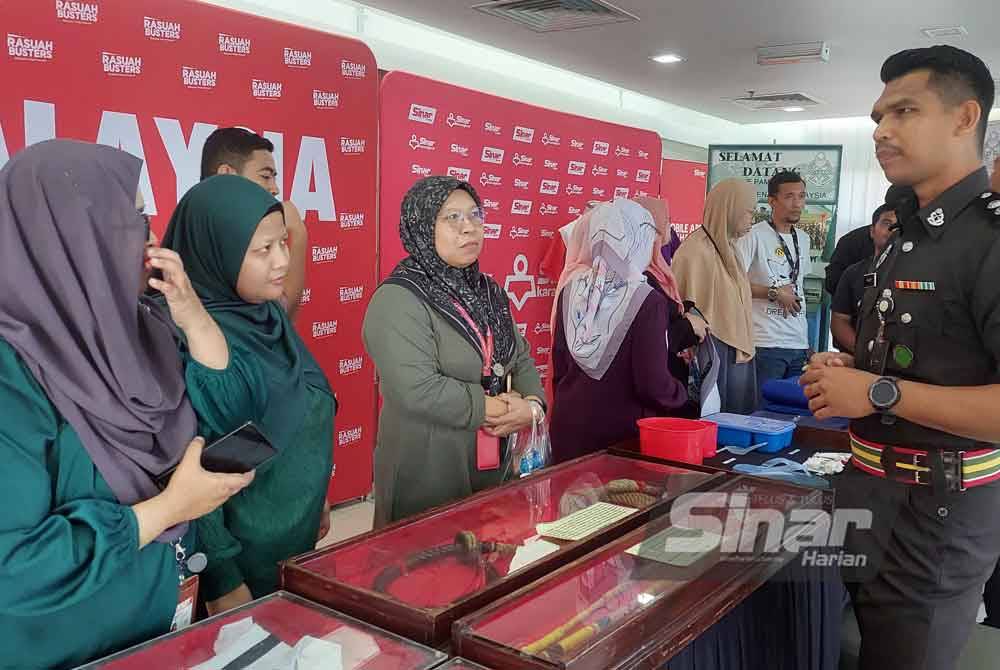 Mohamad Zulfahmi (kanan) memberi penerangan mengenai rotan yang dipamerkan di reruai Jabatan Penjara sempena HARA Rasuah Busters di Kompleks Kumpulan Karangkraf, Shah Alam pada Rabu. Foto SINAR HARIAN/ASRIP ASWANDI SHUKOR