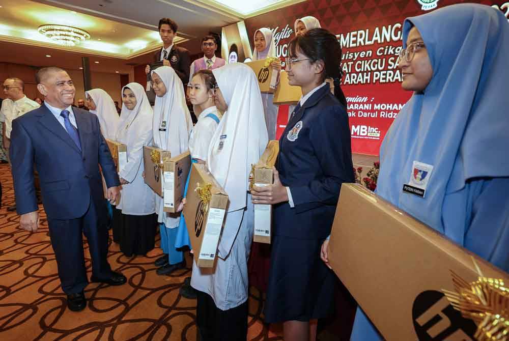 Saarani (kiri) beramah mesra bersama pelajar yang mendapat keputusan cemerlang dalam peperiksaan percubaan SPM 2023 pada Majlis Hari AACS dan Pelajar Inisiatif Tuisyen Cikgu Saarani Daerah Kinta di bawah Program TRAS, hari ini. - Foto Bernama