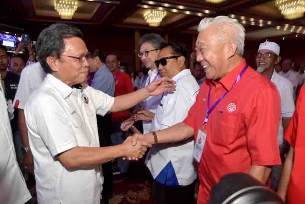 Bung Moktar (kanan) bersalam dengan Mohd Shafie ketika hadir pada Perhimpunan Agung Tahunan Parti Warisan yang diadakan di Dewan Hakka Likas, Kota Kinabalu.