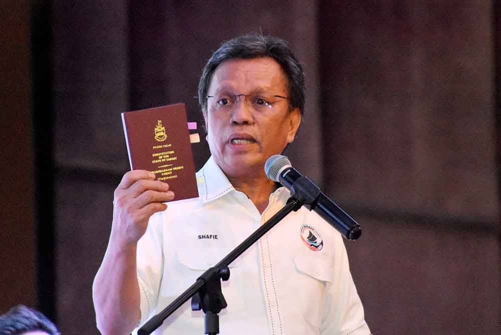 Mohd Shafie menunjukkan buku Perlembagaan Negeri Sabah sebagai rujukan beliau menyatakan bahawa GRS sebuah gabungan parti politik yang gagal ketika berucap pada Perhimpunan Agung Tahunan Parti Warisan di Dewan Hakka Likas, Kota Kinabalu.