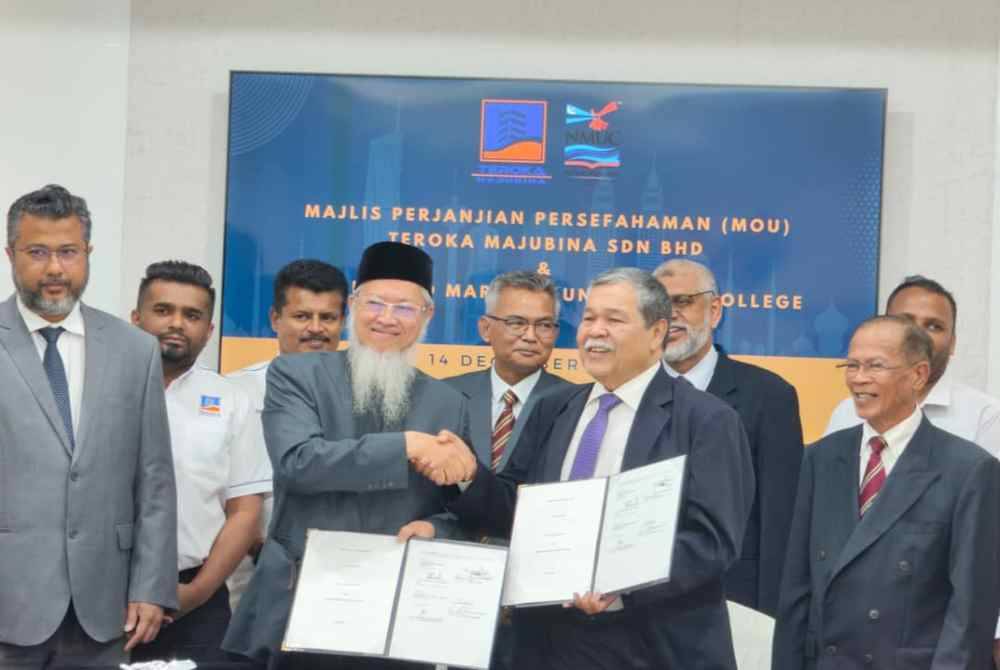 Abd Radzak (kanan) dan Razali bertukar dokumen MoU yang ditandatangani dalam satu majlis Kuala Lumpur pada Khamis.