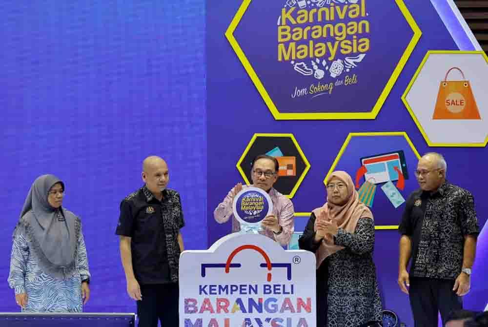 Armizan (dua dari kiri) mengiringi Anwar (tengah) ketika merasmikan Karnival Barangan Malaysia (KBM) 2023 di Putrajaya hari ini. - Foto: Bernama