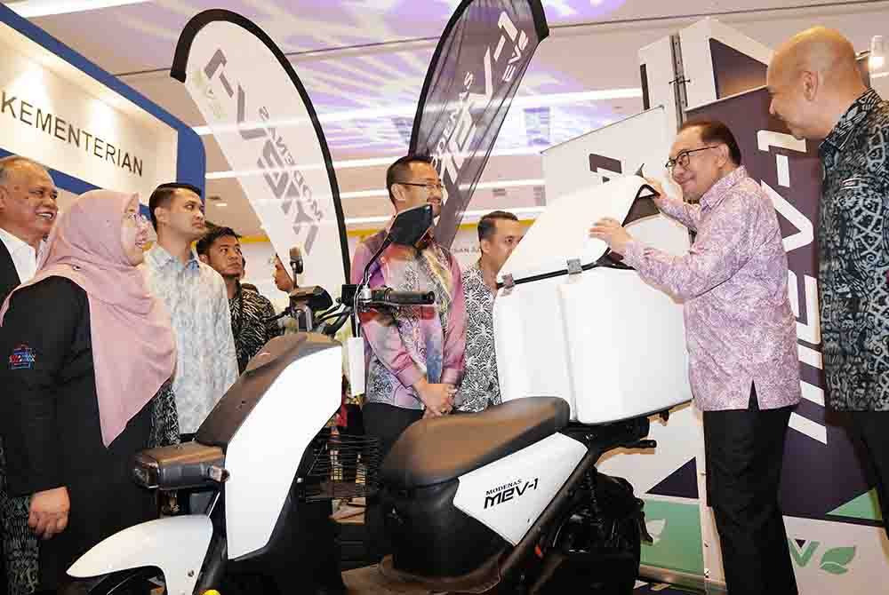 Anwar (dua dari kanan) melihat model motosikal elektrik Modenas MEV-1 selepas merasmikan Karnival Barangan Malaysia (KBM) 2023 yang diadakan pada Khamis.