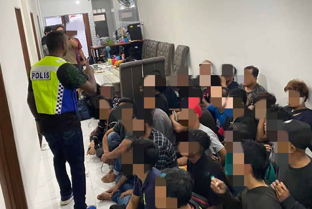 Polis membongkar sebuah rumah inap desa dan menahan PATI di Jalan Kebun, Shah Alam pada Khamis.