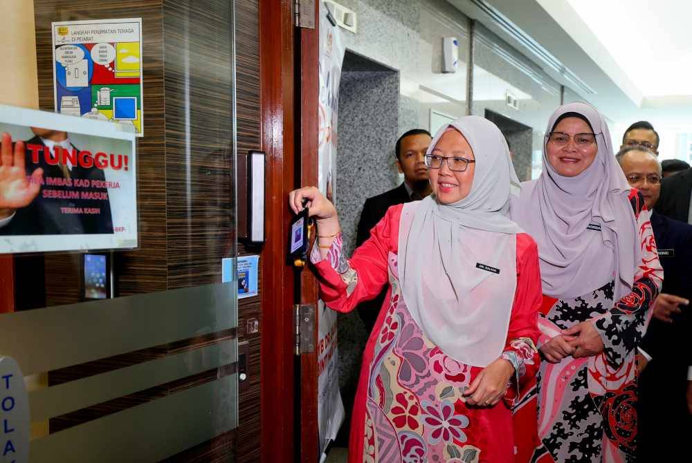 Dr Zaliha (kiri) mengimbas kad perakam waktu sebelum hadir pada sesi Taklimat Khas Bersama Jabatan Wilayah Persekutuan dan Agensi di Menara Seri Wilayah, Putrajaya hari ini. - Foto Bernama