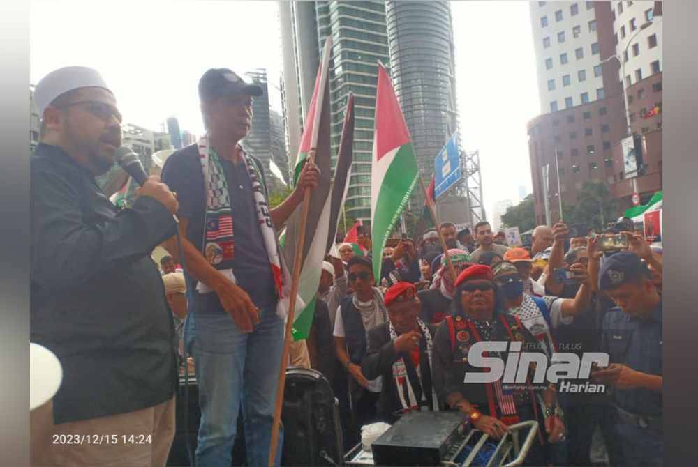 Peserta tetap bersemangat menyatakan bantahan terhadap kekejaman Israel walaupun dalam keadaan hujan ketika Himpunan Malaysia Bangkit Tolak Veto Amerika di PBB berdekatan Kedutaan Amerika Syarikat, Jalan Tun Razak pada Jumaat.