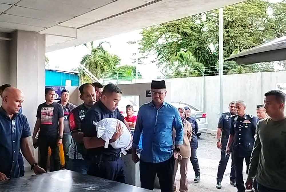 Mohd Azman memangku jenazah anaknya, Muhammad Hafiy sebelum dibawa ke dalam kereta jenazah untuk dibawa pulang ke Kampung Pintu Gerbang,Bachok, Kelantan.