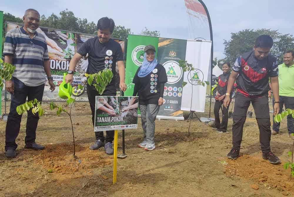 Mohd Najwan (dua dari kiri) menyiram pokok yang ditanam sebagai simbolik kepada Program Hari Kesukarelawan Belia Malaysia Peringkat Negeri Selangor di Puncak Alam Golf Driving Range pada Sabtu.