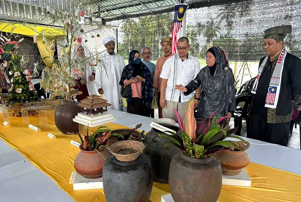 Profesor Madya Ahamad Tarmizi (kanan) mengiringi Nik Ahmad Shazzwan (tiga dari kanan) melihat pameran replika istiadat berkhatan Kesultanan Melayu Kelantan.