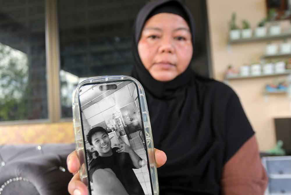 Ibu arwah Muhammad Zaharif Affendi Muhd Zamrie, 17, Mimi Julia Ismail, 50 kelihatan sedih sambil menunjukkan gambar anaknya di kediaman keluarganya di Taman Chepor Sentosa Chemor pada Sabtu. - Foto: Bernama