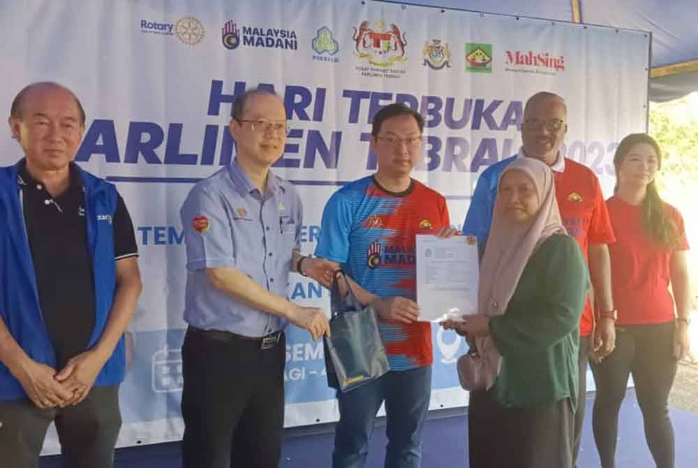 Jimmy (tengah) menyerahkan sijil kepada penerima pada Hari Terbuka Parlimen Tebrau 2023, Mini Karnival Kerjaya, Pemeriksaan Kesihatan Percuma dan Sukan Rakyat Futsal Bistari Perdana di Bandar Bistari Perdana, Pasir Gudang pada Ahad.