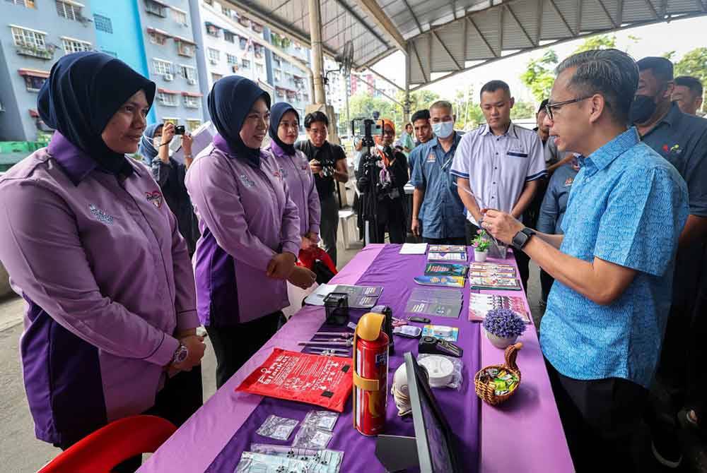 Fahmi Fadzil (kanan) melawat reruai Skuad Aman Wanita (Amanita) PDRM yang terdapat pada program ‘RENEW: Reuse, Educate, Nurture and Empower with Waste’ kerjasama ICEPS UiTM di Dataran Sri Angkasa Jaya pada Ahad. - Foto: Bernama