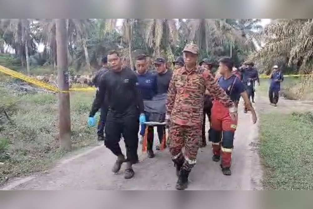 Anggota penyelamat membawa mayat veteran komando selepas ditemui di dalam kebun kelapa sawit di Kampung Palembang, Kluang pada Ahad.