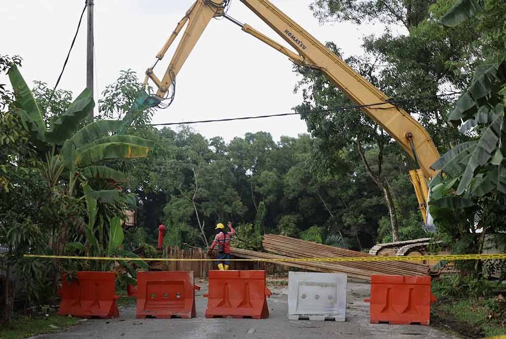 Kerja-kerja pemasangan cerucuk besi bagi mengawal pergerakan tanah di Jalan Wawasan, Puchong, di sini, susulan kejadian tanah runtuh semalam. - Foot Bernama