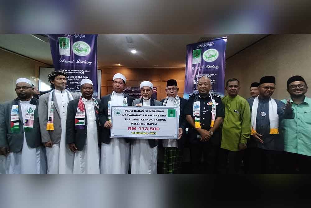 Mohd Azmi (lima kanan) mewakili Mapim menerima sumbangan daripada Majlis Agama Islam Pattani untuk disalurkan kepada rakyat Palestin melalui Dr Ahmad Kamel (empat kiri).