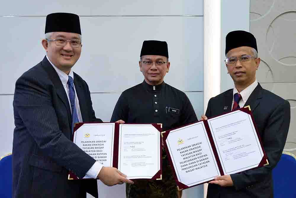 Mohd Na&#039;im Mokhtar (tengah) menyaksikan pertukaran memorandum persefahaman antara Ketua Pegawai Eksekutif YWM, Dr Ridzwan Bakar (kanan) bersama Pengarah Bahagian Pembangunan Perniagaan LC Wakaful Digital Sdn Bhd Rizal Kamaruzzaman (kiri) pada majlis menandatangani Kerjasama Strategik antara Yayasan Wakaf dan LC Wakaful Digital pada Selasa. Foto: Bernama