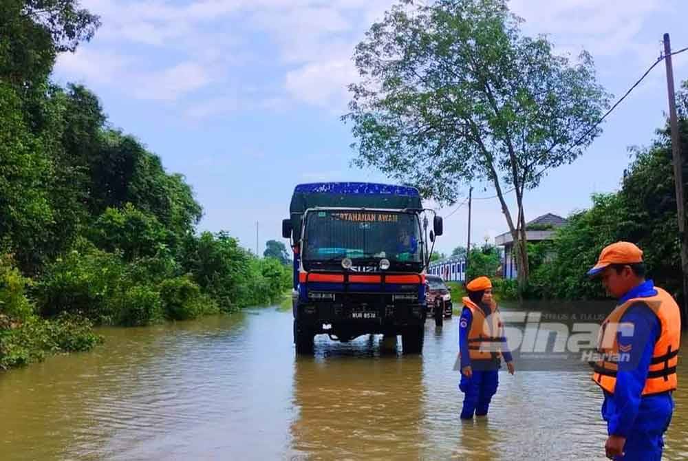 Anggota APM membuat tinjauan banjir pada laluan di Kampung Bukit Pedah, Rantau Panjang. - Foto: APM