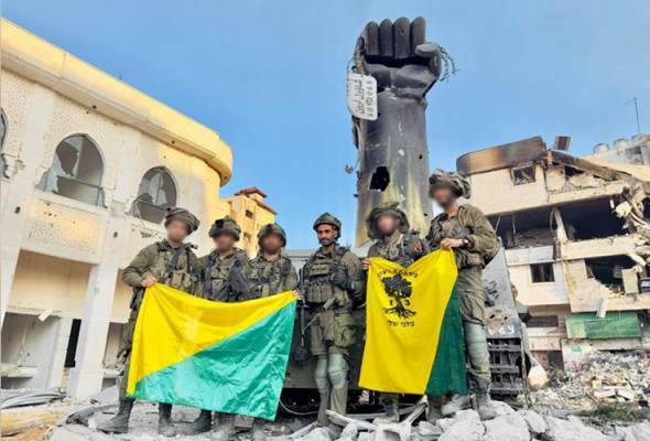 Anggota tentera Batalion ke-13 Israel bergambar bersama monumen ikonik Perang Gaza 2014 sebelum memusnahkannya. - Foto X/Emanuel (Mannie) Fabian