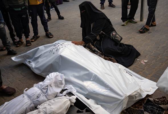 Seorang wanita Palestin meratap pemergian ahli keluarganya yang terbunuh dalam serangan udara yang dilancarkan Israel di Semenanjung Gaza, pada Selasa. - Foto AP