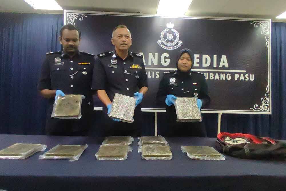 Ketua Polis Daerah Kubang Pasu, Superintendan Rodzi Abu Hassan (tengah) menunjukkan ketulan mampat disyaki dadah jenis ganja dirampas di parkir kenderaan di RTC Napoh, Changlun, di sini,pada Isnin lepas.