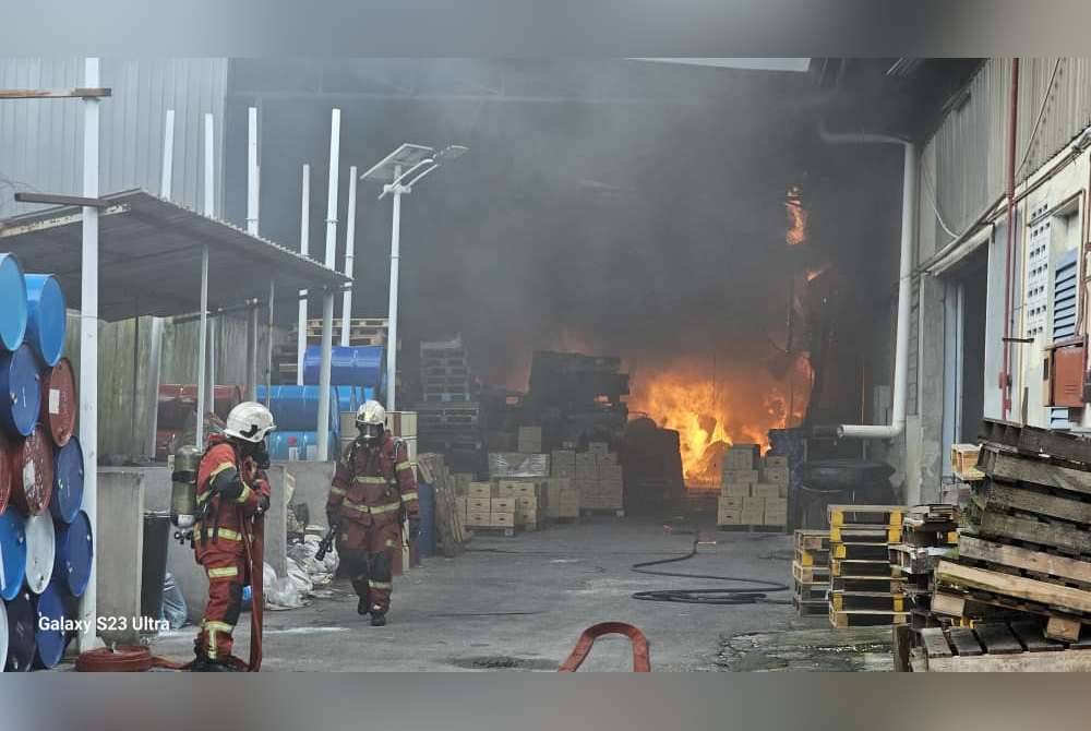 Anggota Bomba dan Penyelamat sedang memadamkan kebakaran kilang di kawasan perusahaan Batu Caves pada Rabu.