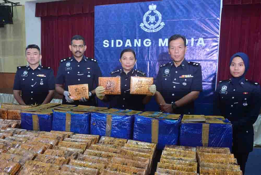 Sasikala (tengah) menunjukkan ketulan mampat daun kering disyaki ganja yang dirampas JSJN Selangor di tepi jalan Lebuhraya Utara Selatan, Kuala Lumpur, Isnin lalu. - FOTO: ASRIL ASWANDI SHUKOR