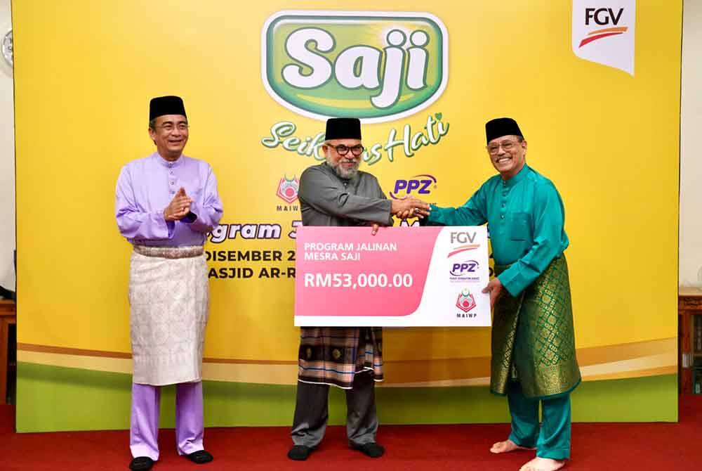 Rastam (tengah) menyampaikan dana wakalah FGV sebanyak RM53,000 untuk diagihkan kepada asnaf dan Food Bank di Masjid Rahimah Kampung Pandan.