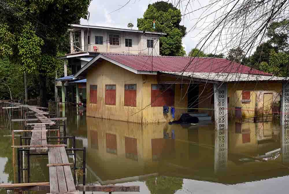 Meskipun keadaan cuaca semakin baik di Kampung Lubok Gong Hilir, Pasir Mas, penduduk terpaksa berdepan masalah banjir termenung di penempatan mereka ketika tinjauan pada Selasa lalu. - Foto Bernama