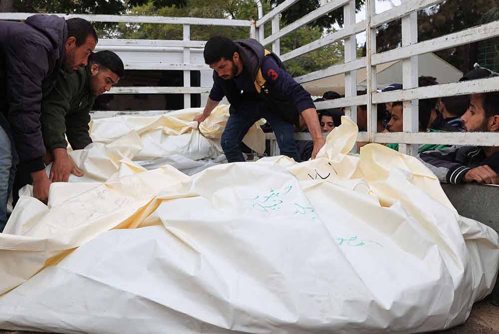 Petugas mengangkat mayat rakyat Palestin, yang terbunuh semasa serangan Israel, dari Hospital EU di Khan Yunis. - Foto AFP