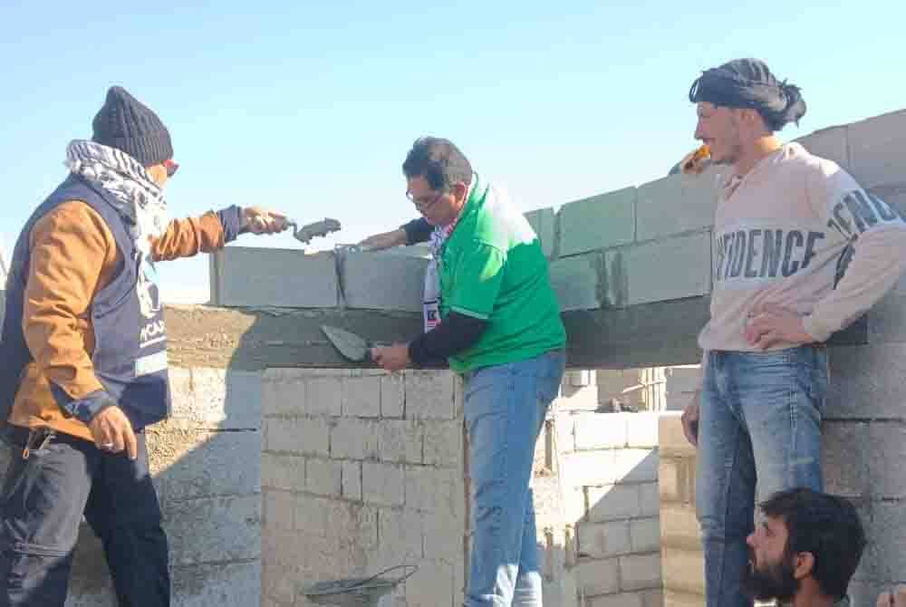 Dr Mohd Zin (kiri) dan Mas Imran mengikat batu sebuah rumah dalam pembinaan untuk pelarian di bandar Albab, Syria, pada Jumaat